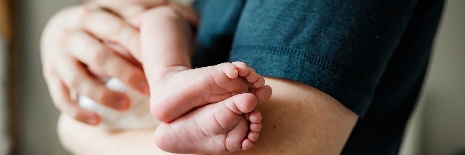 Ouder met pasgeboren baby in de armen als illustratie voor geboorteverlof en ouderschapsverlof onder de nieuwe Verlofwet